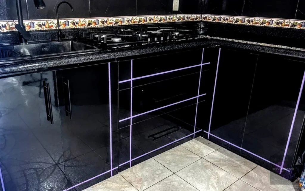 Módulo inferior de cocina integral negra con 3 cajones amplios, detalles en morado y herrajes de primera calidad — Cocinas a la medida SERVESPROGAR Ecatepec